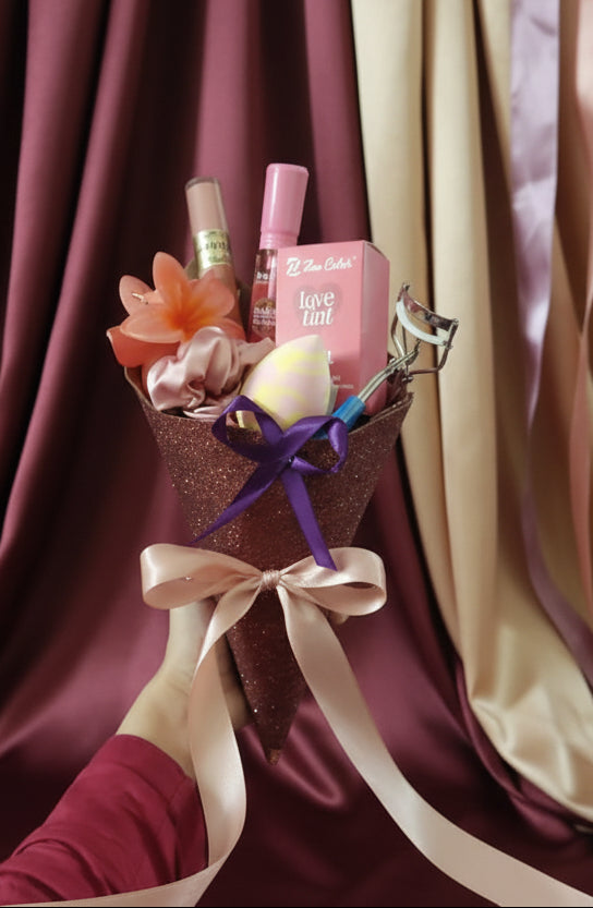 Bouquet of flowers with a pink box and makeup items against a red patterned background